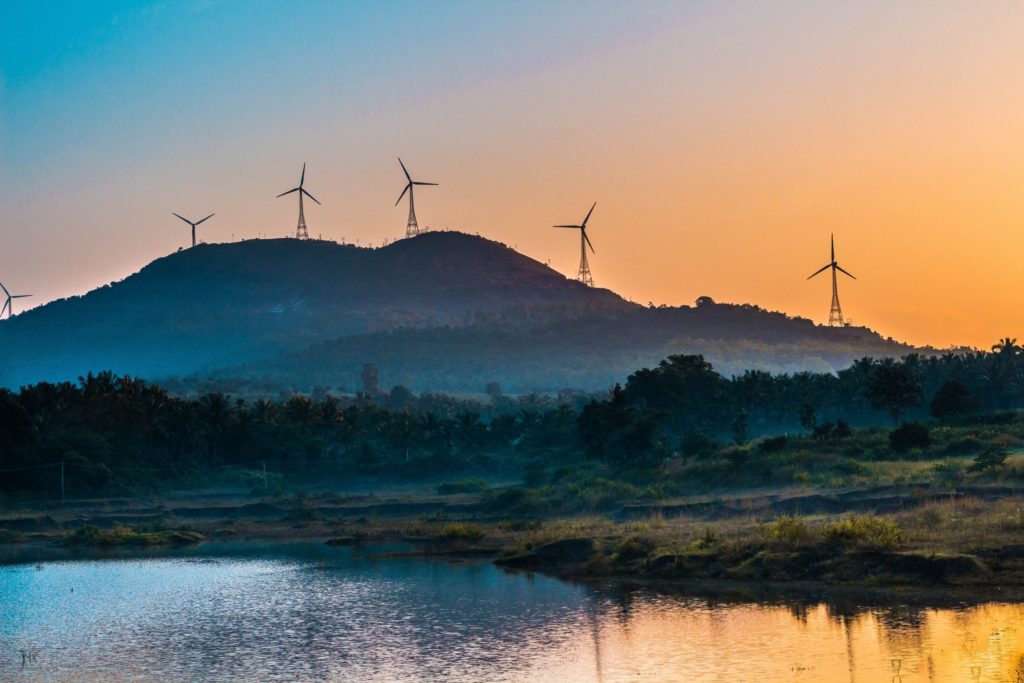 windmills-in-mountain-viewing-lake-under-orange-skies-2861857-scaled-1024x1024